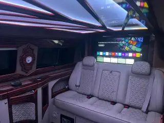 Transfer aracında açık renk yolcu koltukları, ekran ve tavan aydınlatması