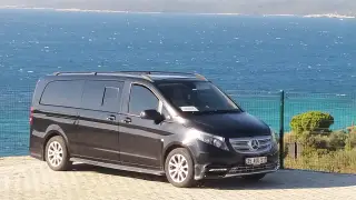 Deniz kıyısında siyah Mercedes transfer aracı, yandan görünüm