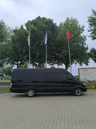 Açık alanda siyah Mercedes grup transfer aracı, yandan görünüm