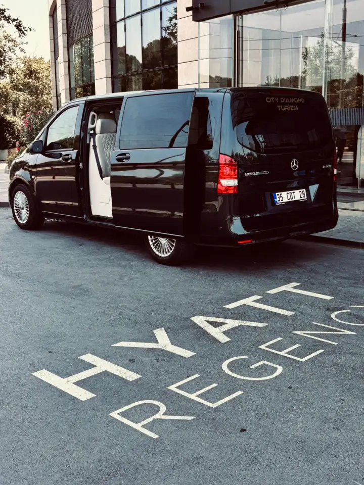 Otel girişinde kapısı açık siyah Mercedes transfer aracı