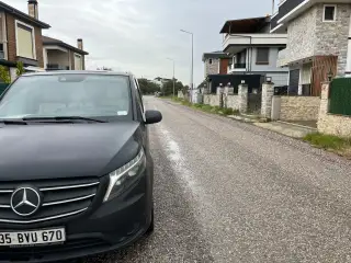 Bina önünde park edilmiş siyah Mercedes Vito transfer aracı