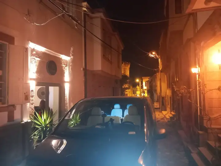 Gece aydınlatılan sokakta siyah Mercedes Vito transfer aracı