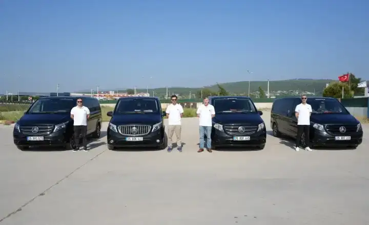 Transferiste sürücü ekibi ve yan yana park edilmiş Mercedes transfer araçları