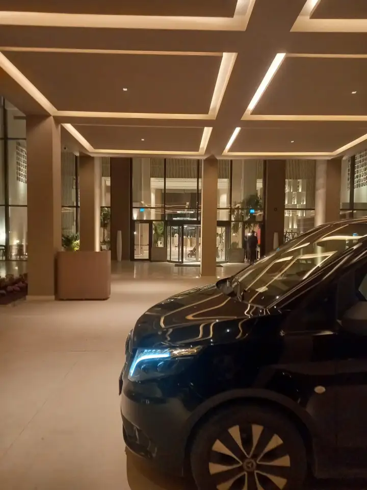 Aydınlatılmış bina girişinde siyah Mercedes Vito