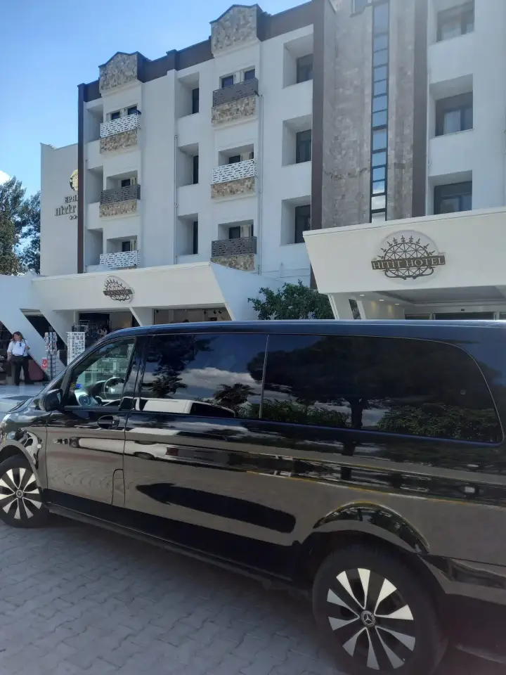 Bina önünde park edilmiş siyah Mercedes Vito transfer aracı