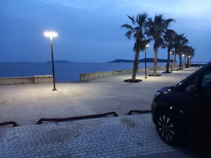 Deniz ve kıyı manzarasının yanında park edilmiş siyah Mercedes Vito