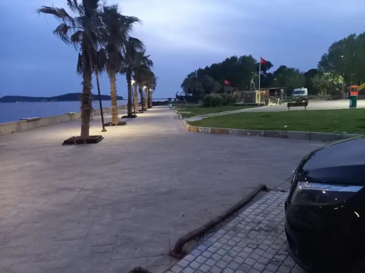 Deniz ve kıyı manzarasının yanında park edilmiş siyah Mercedes Vito