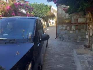 Taş binaların yanında park edilmiş siyah Mercedes Vito
