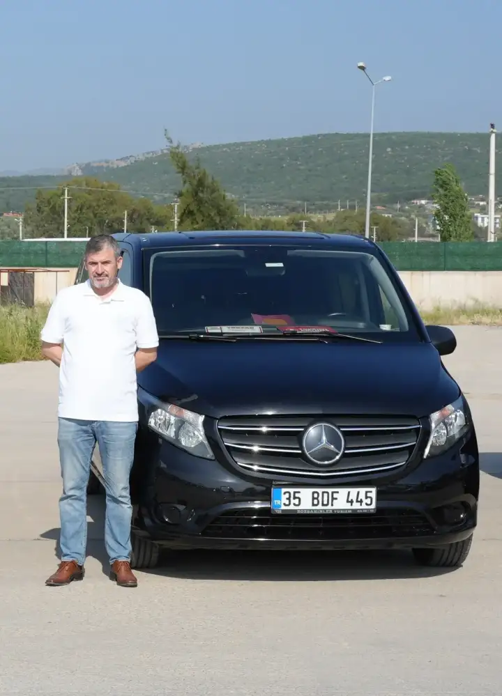 Siyah Mercedes transfer aracının yanında duran sürücü