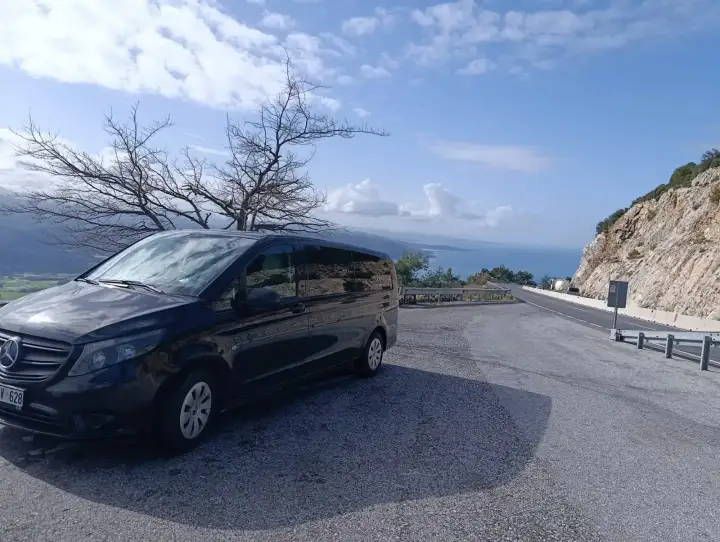 Dağlık manzara önünde park edilmiş siyah Mercedes Vito