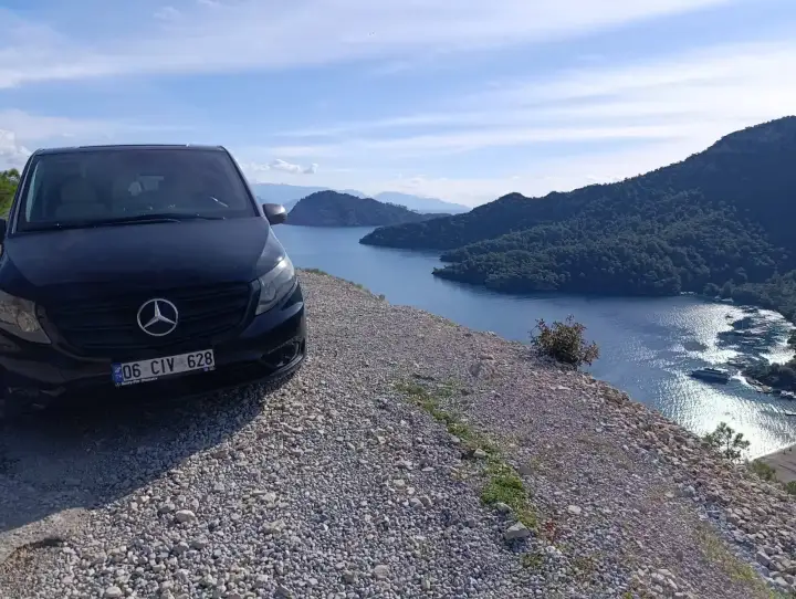 Deniz ve kıyı manzarasının yanında park edilmiş siyah Mercedes Vito